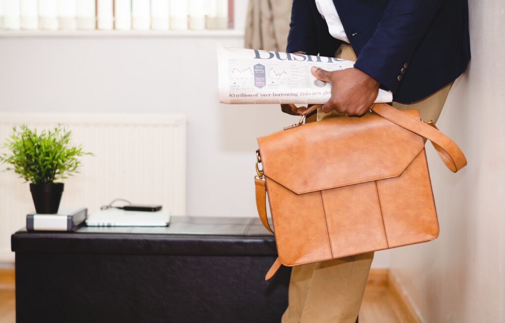 Businessman and briefcase and newspaper after unfair exit