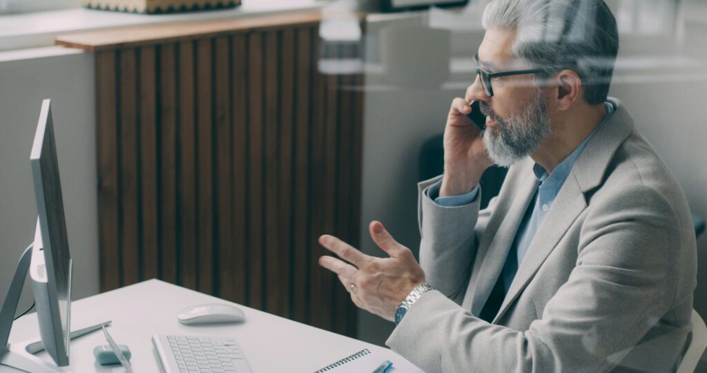 Man negotiating employment agreement on phone in office
