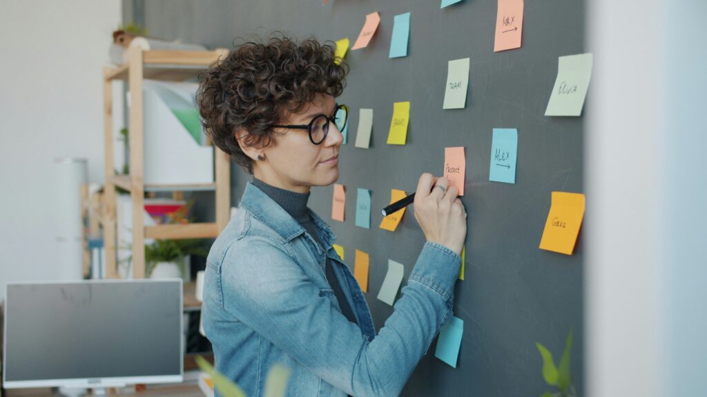 Woman reviewing redundancy business process using notes